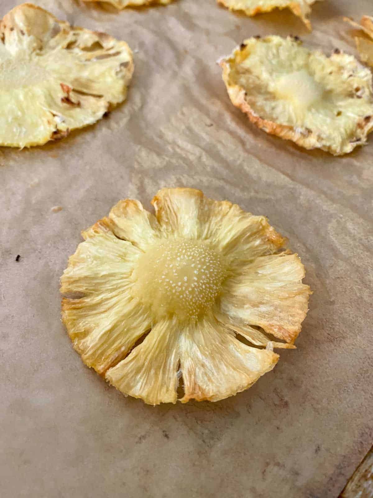 baked pineapple "flowers" on parchment paper