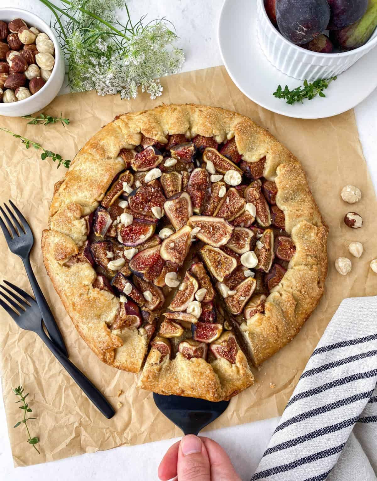 Overhead view of sliced Hazelnut Fig Galette with slice being lifted
