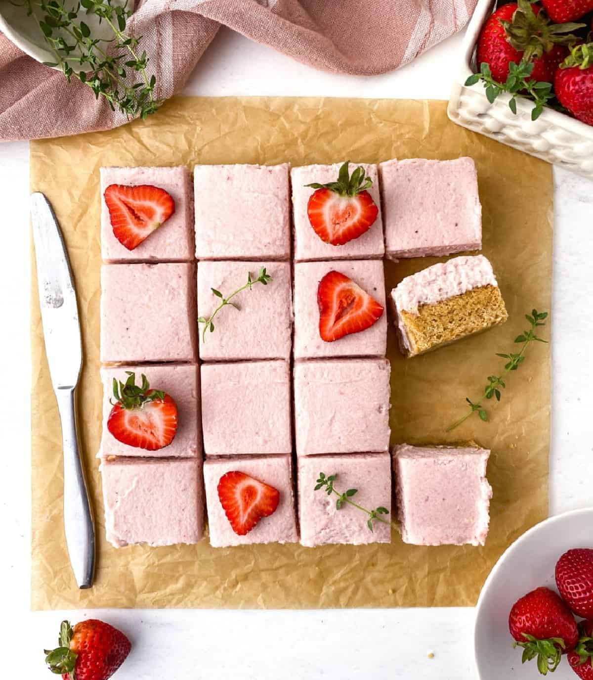 Top view of sliced Strawberry Thyme Blondies with sliced strawberries and thyme sprigs on top.