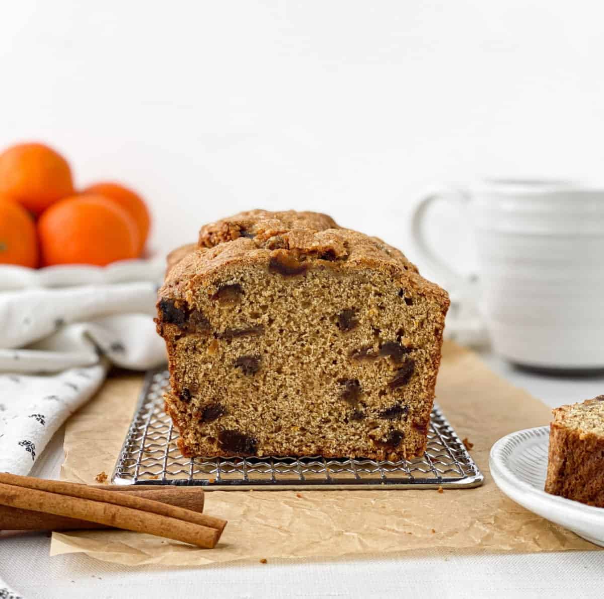 Front view of sliced Date Bread with cinnamon sticks in the foreground.