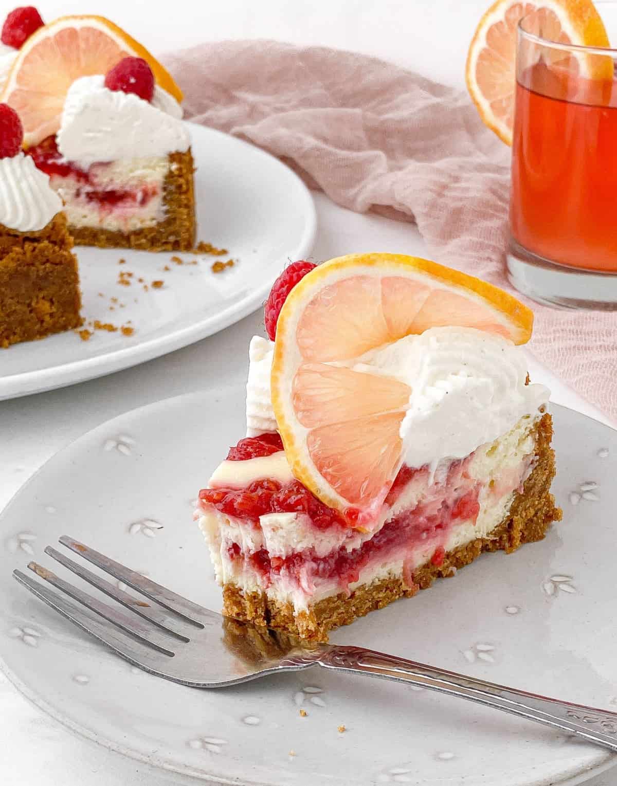 Slice of Raspberry Lemonade Cheesecake with a bite missing.