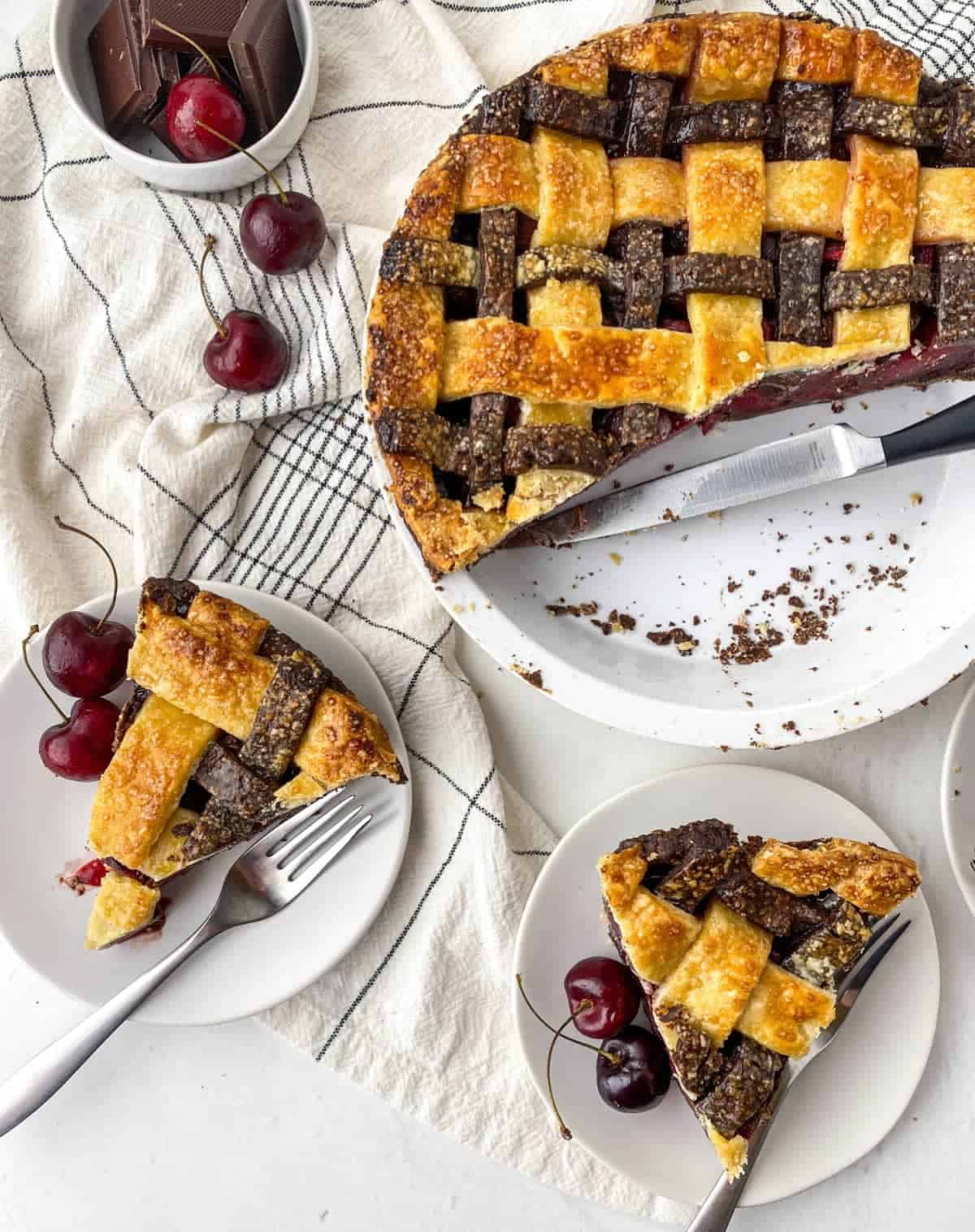 Top view of sliced Chocolate Cherry Pie with fresh cherries and chocolate in a bowl.