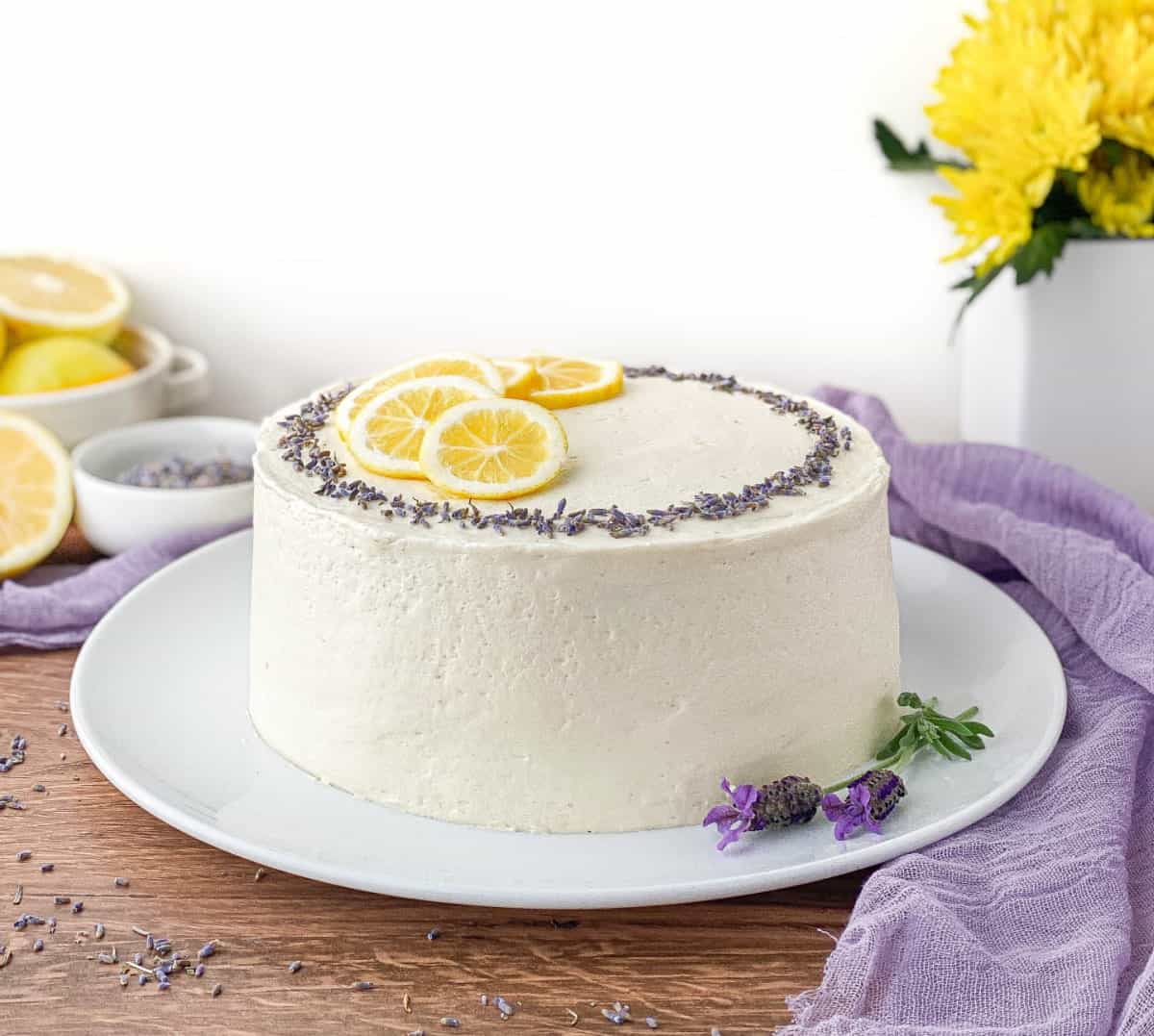 Lavender Lemon Cake with lavender flowers and lemons nearby.