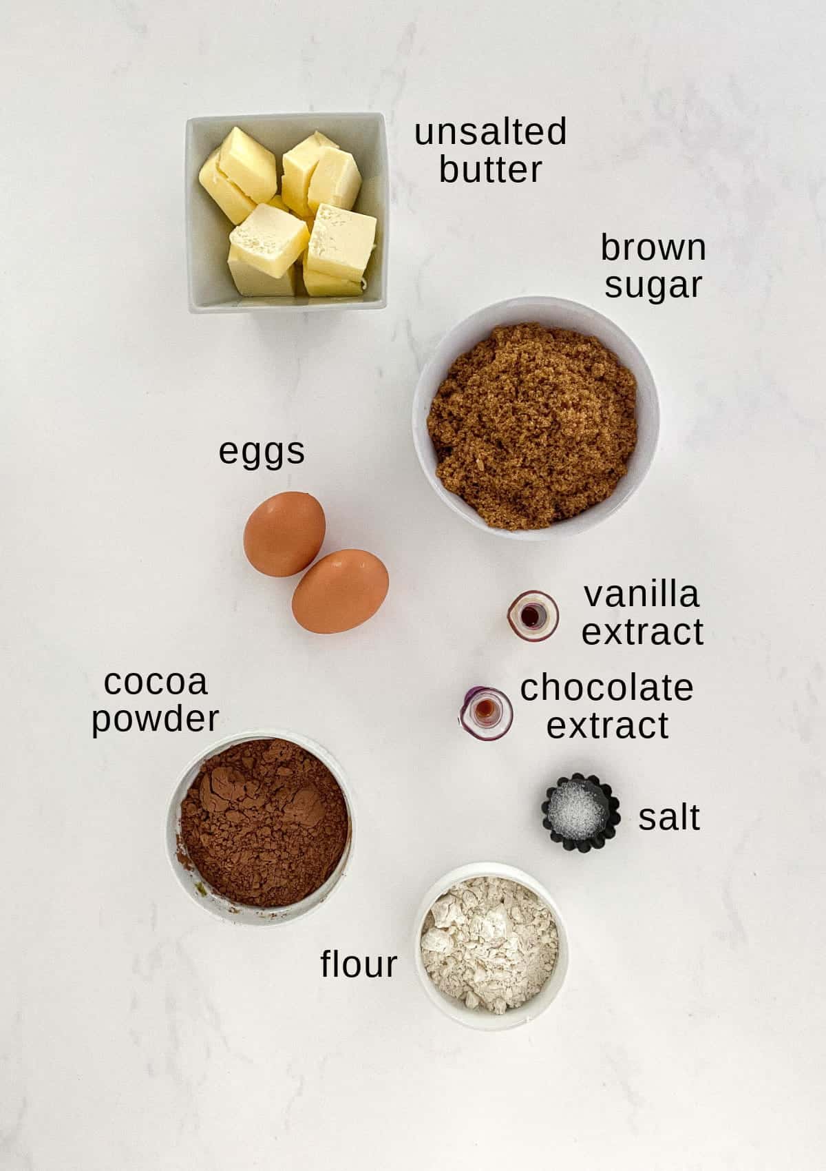 Top view of brownie layer ingredients on a white background.