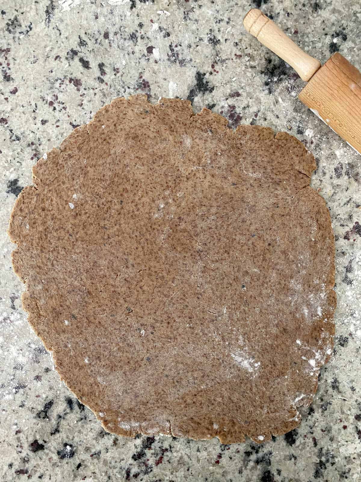 Espresso sugar cookie dough rolled out on a countertop.