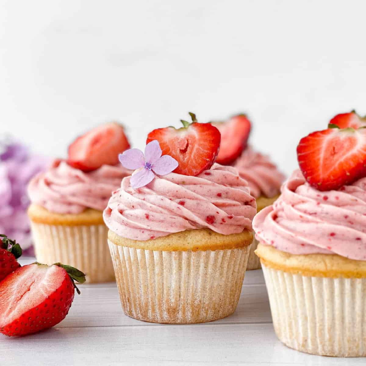 Strawberry Filled Cupcakes with fresh strawberries on top.