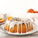 Peach Cobbler Pound Cake with bourbon glaze and fresh peaches on top.