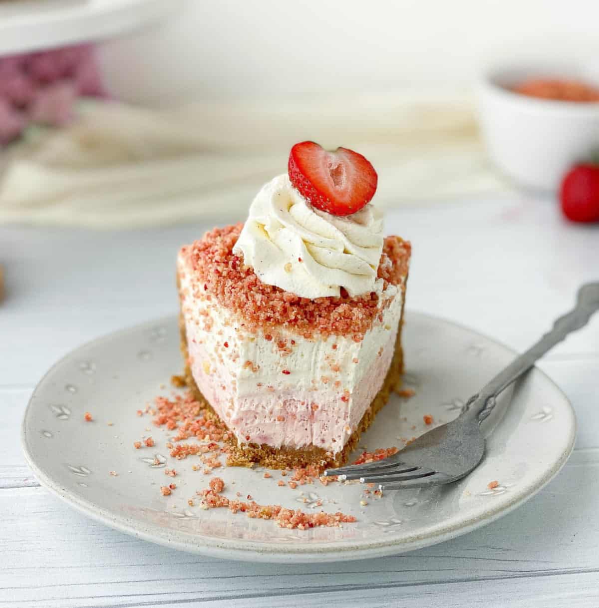 Slice of Strawberry Crunch Cheesecake with bite.
