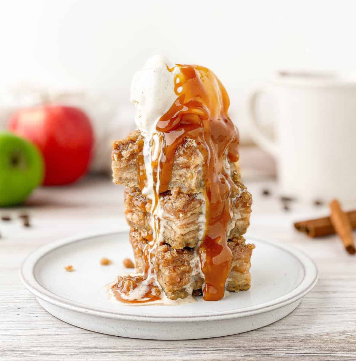 Stacked Apple Crisp Macchiato Bars topped with vanilla ice cream and salted caramel sauce.