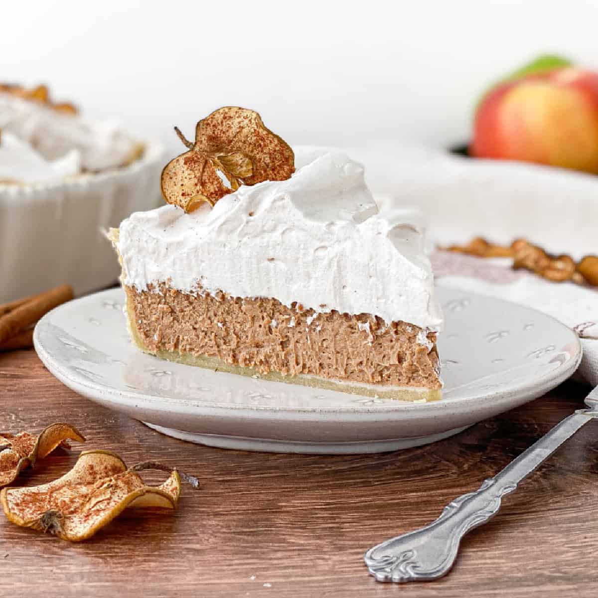 Slice of Cinnamon Pie with apple cider meringue on a white plate.