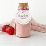 Glass jar of Strawberry Sugar with cork in top and gift tag on front.
