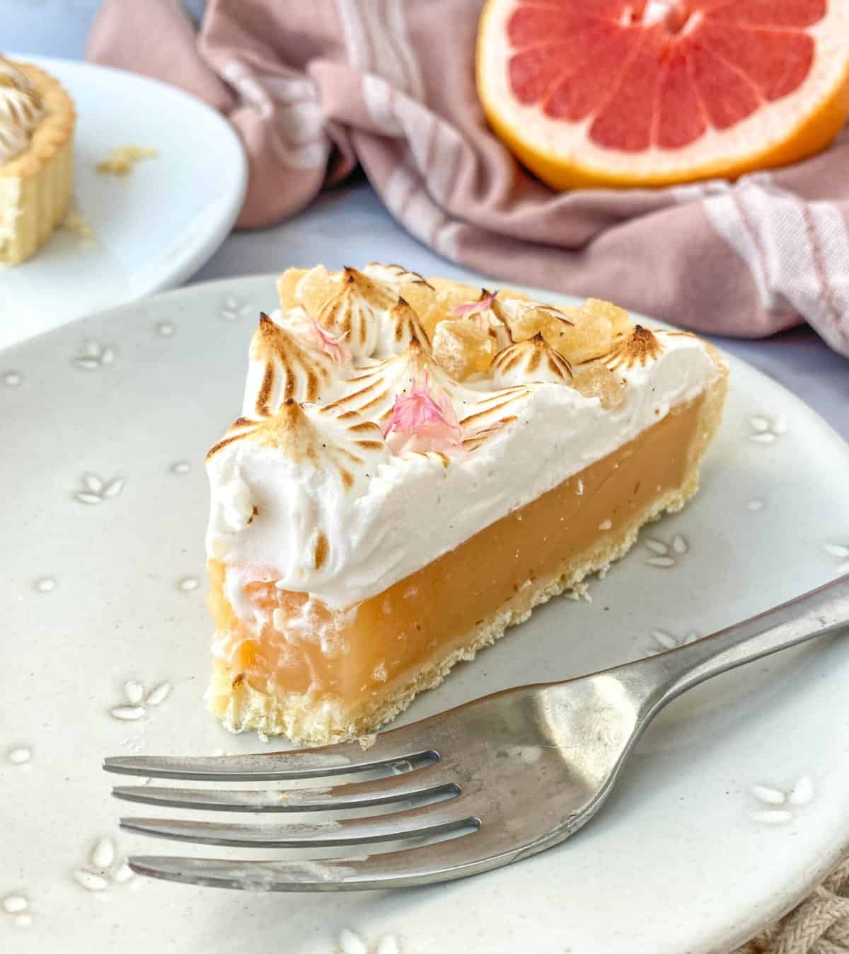 Ginger Grapefruit Tart with bite missing on a white plate.