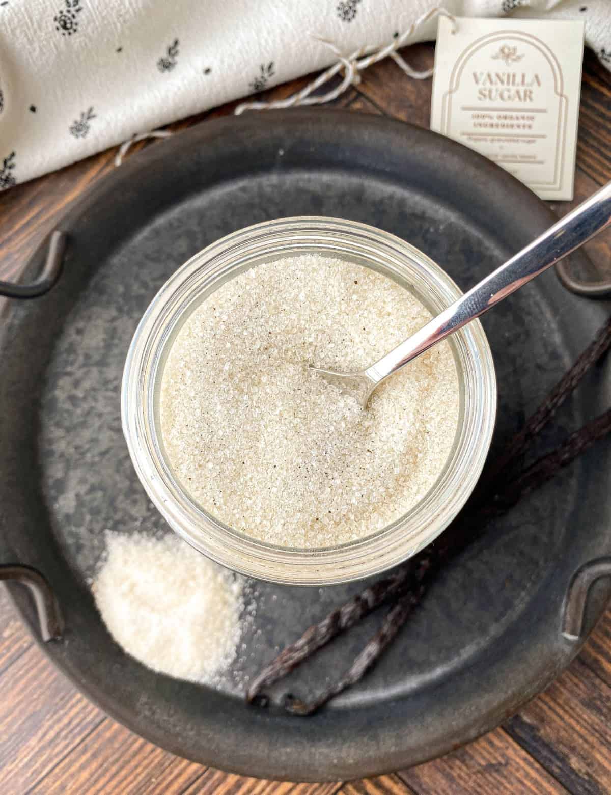 Top view of Homemade Vanilla Sugar in a jar with a silver spoon.