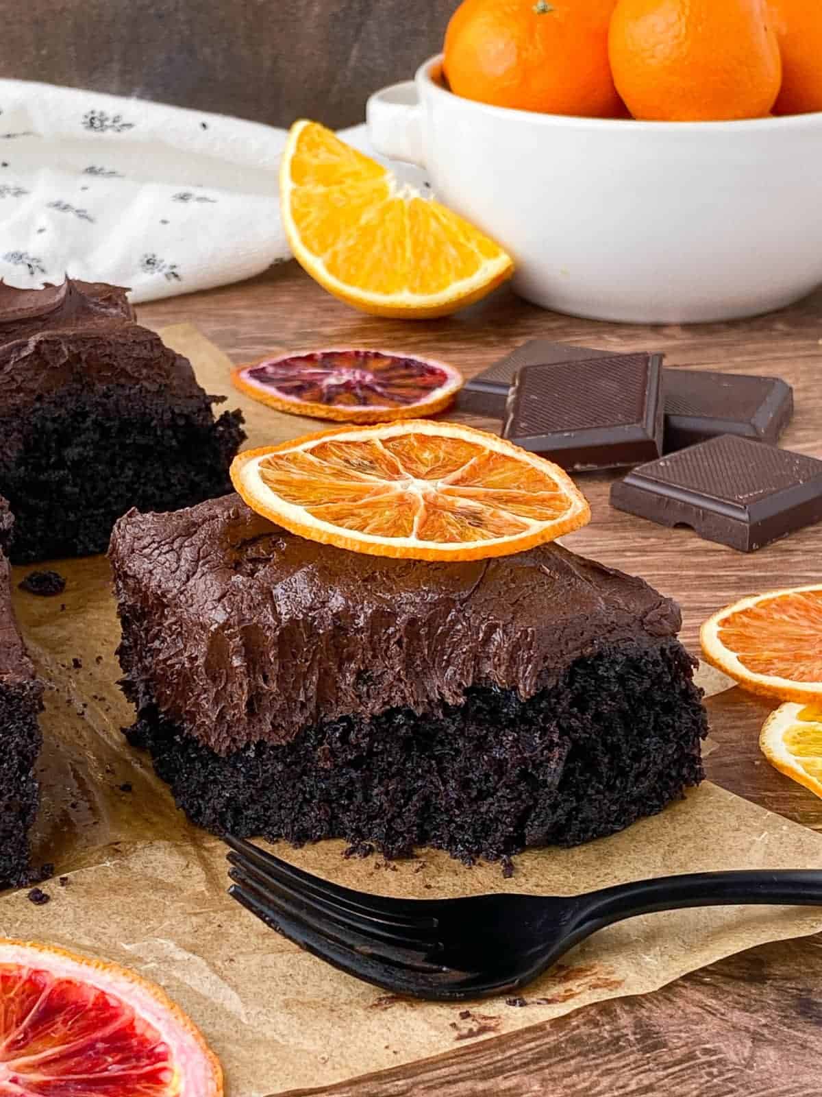 Slice of Chocolate Orange Cake with bite missing and a black fork alongside.