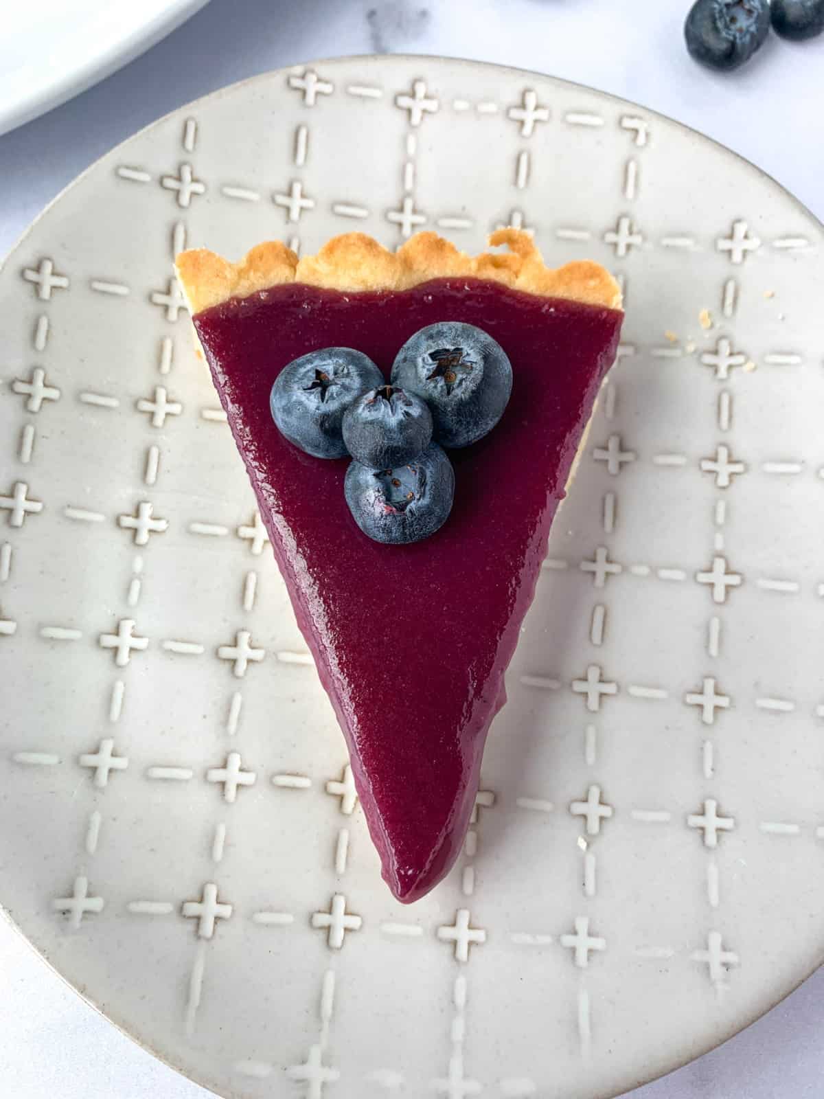 Top view of slice of Blueberry Curd Tart.