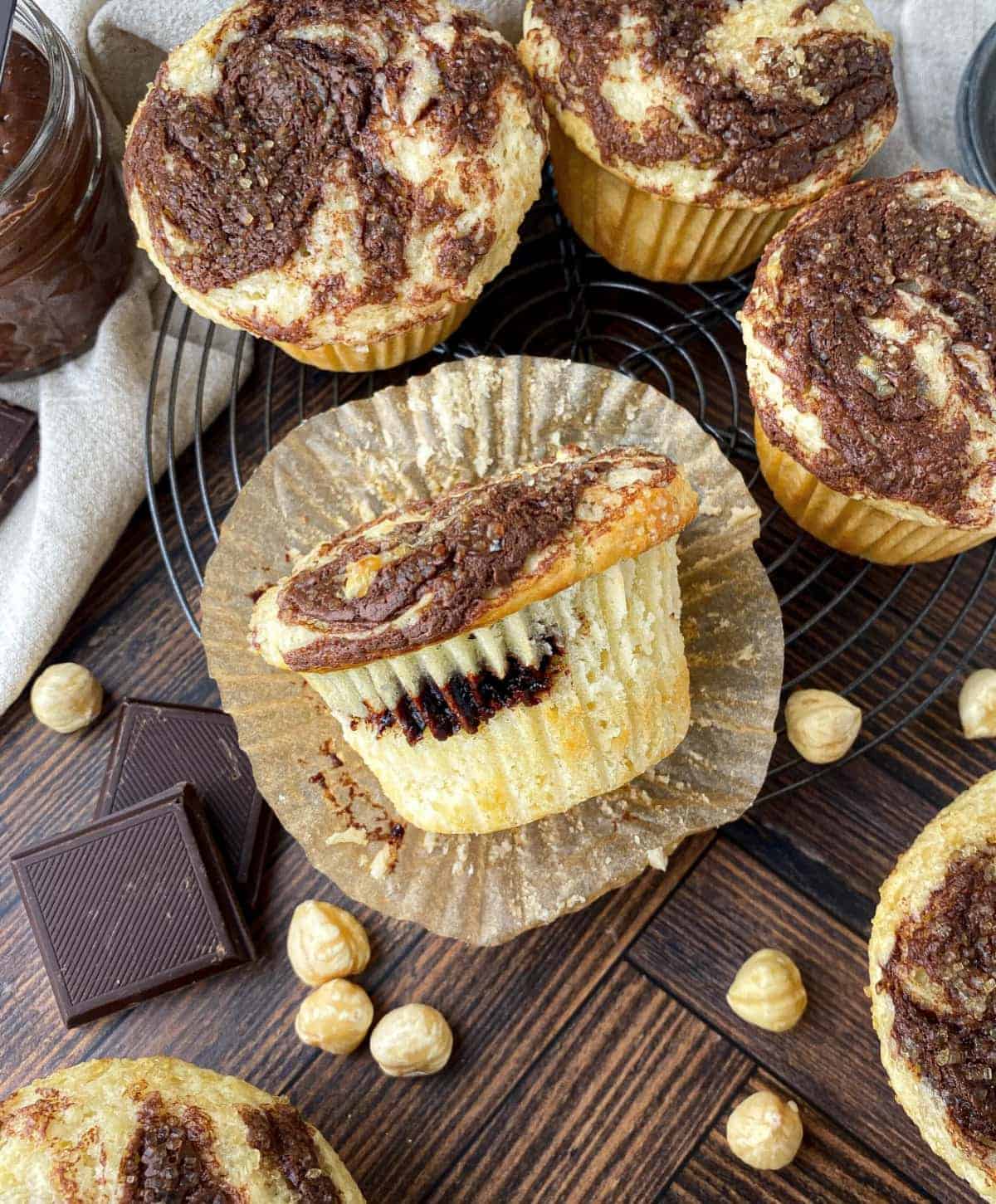 Top view of Nutella Muffins with hazelnuts and chocolate nearby.
