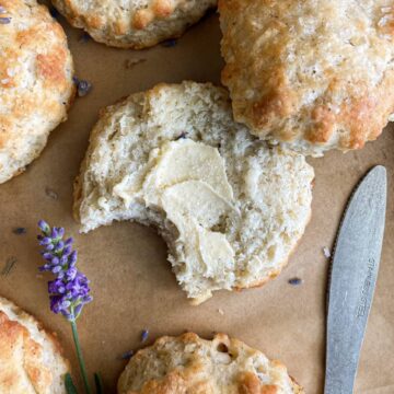 Top view of Lavender Biscuit with butter with a bite missing on parchment paper.