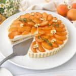 Apricot Tart on a white plate with a slice missing.
