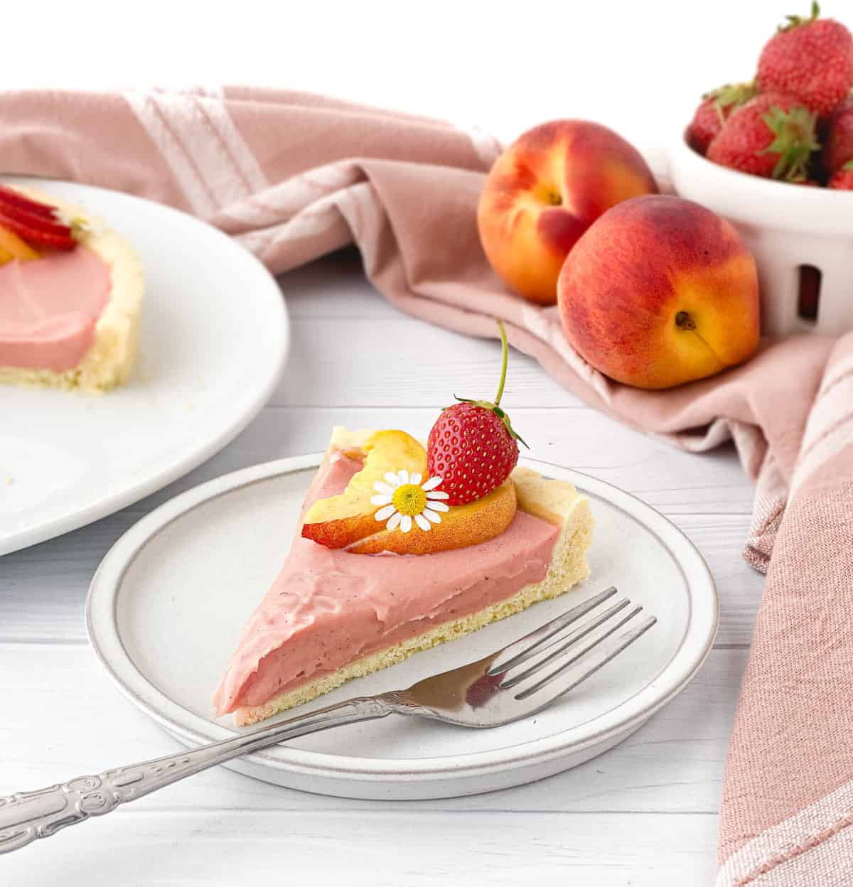 Slice of Strawberry Peach Tart on a white plate.