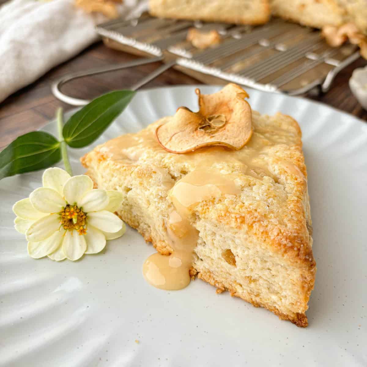 Ginger Scone topped with apple glaze and a homemade apple chip on a white plate.