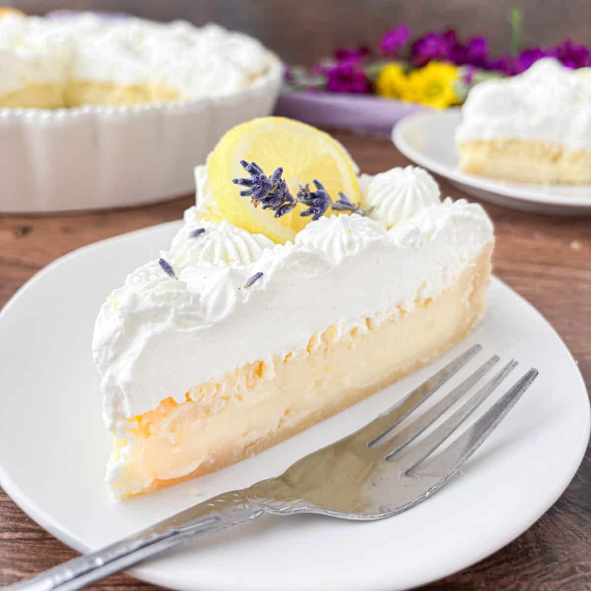 Slice of Lemon Buttermilk Pie on a white plate with a silver fork.
