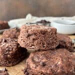 A closeup of Chocolate Biscuits stacked on parchment paper.